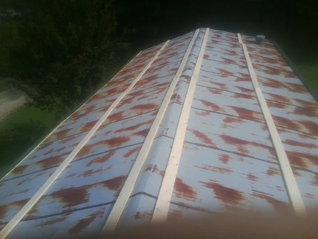 Rusted metal roof panels with new wood purlins before replacement — Storm Damage Roof Repair in Branchville by Roofing Brothers