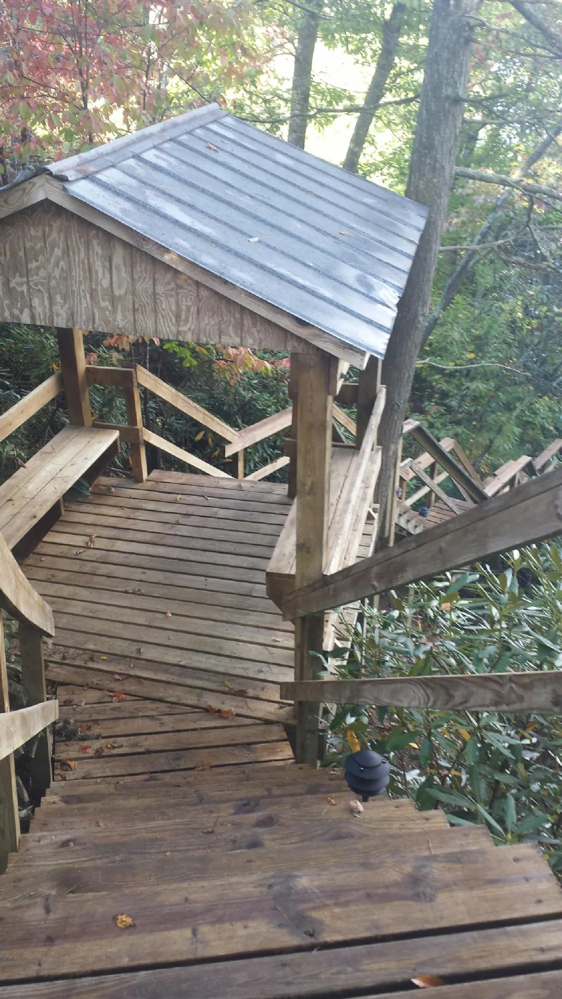 Metal roofed shelter over wooden steps on a wooded walkway — Skylight Repair & Installation work by our crew in Branchville