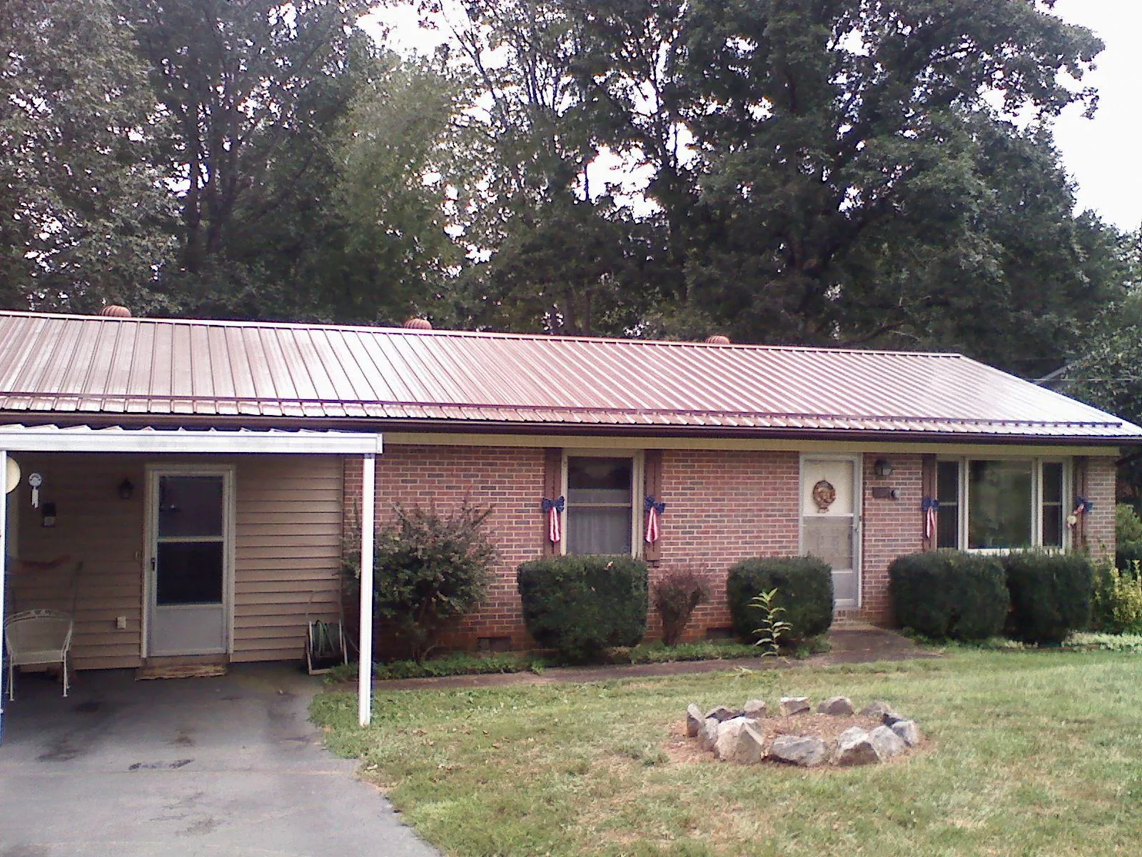 Bronze metal roof and carport on a brick ranch home — Roof Repair work by our crew in Branchville
